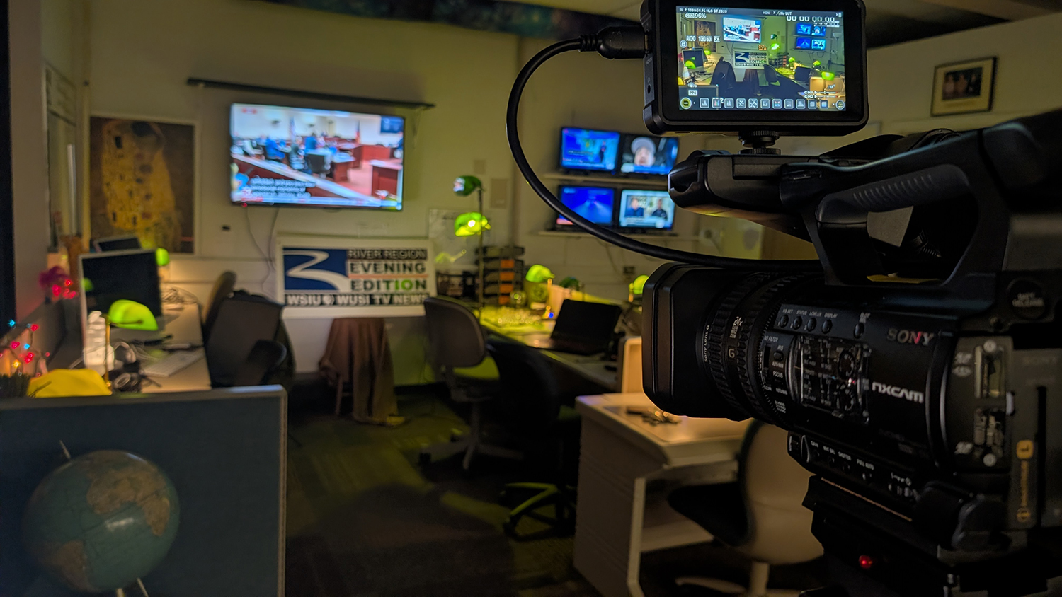 Image of newsroom space with camera and computers.