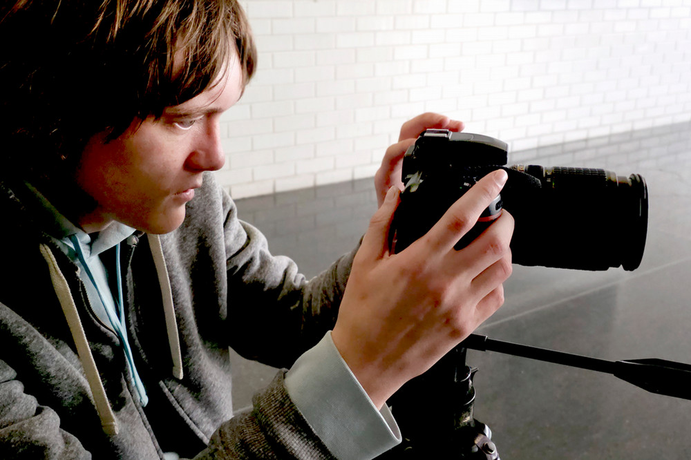 student composing with DSLR camera.